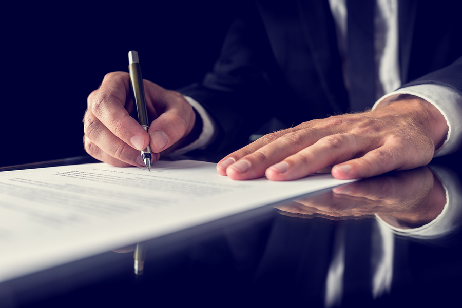 Close up of businessman's hands as he signs a document