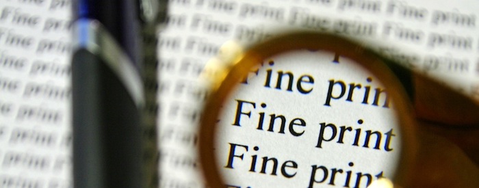 Page of small type with magnifying glass showing the words "fine print"