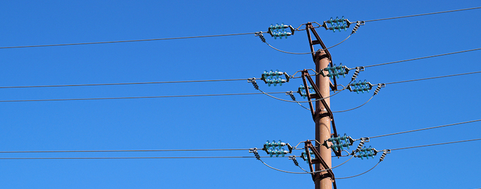 Telephone pole against a bright blue sky.